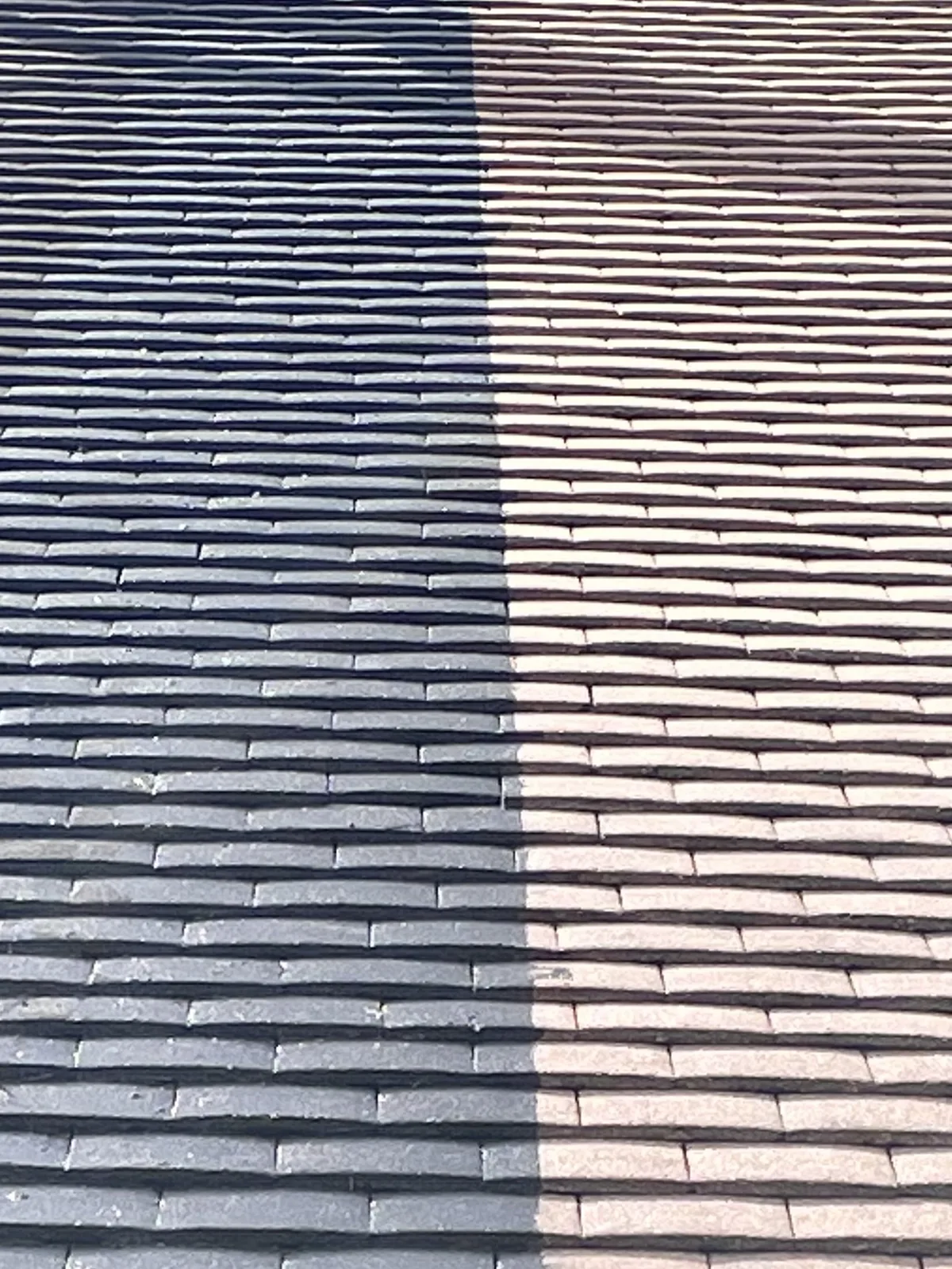 Deux zones de tuiles, l'une sombre et l'autre plus claire, séparées par une limite visible pendant le chantier