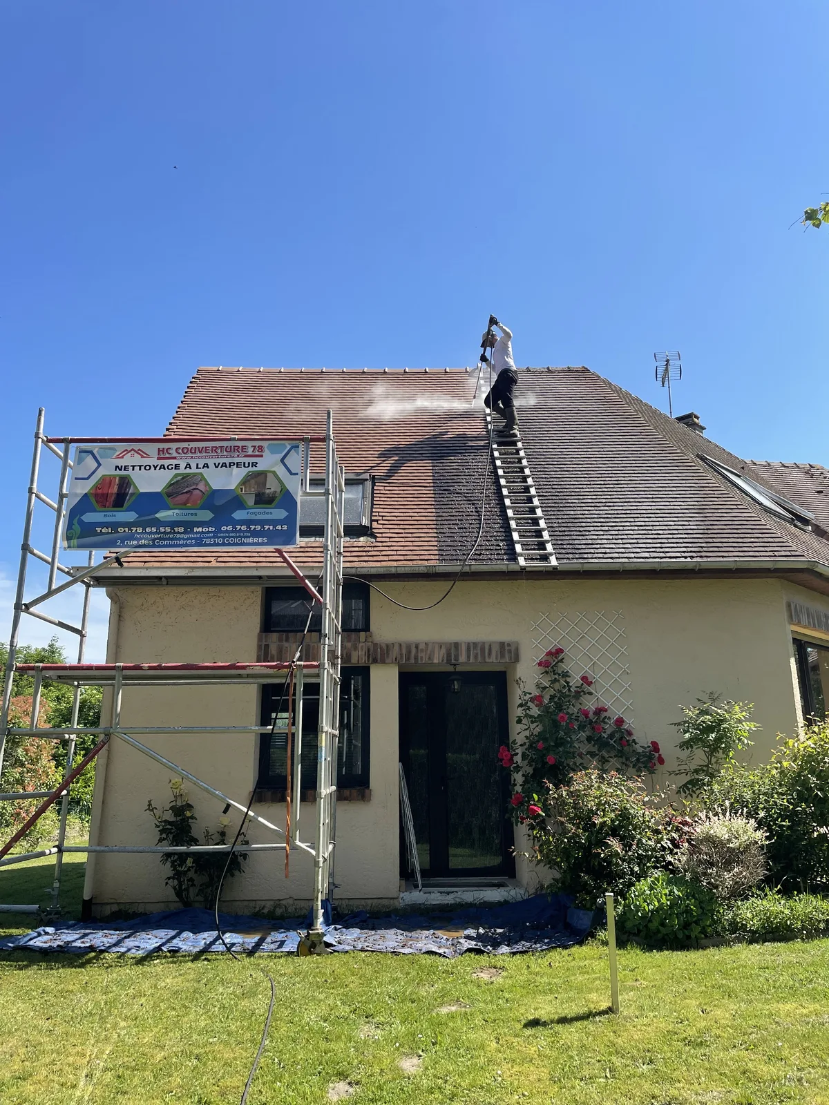 Intervenant sur une échelle de toit, avec une bande de toiture plus claire pendant le nettoyage en cours
